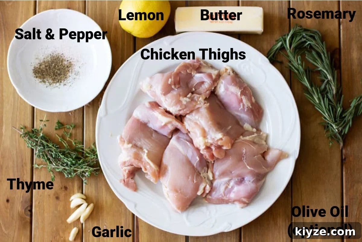 Wooden table containing ingredients for a Lemon Thyme Chicken which includes raw chicken thighs, fresh thyme and rosemary, garlic, butter, lemon, salt and pepper.