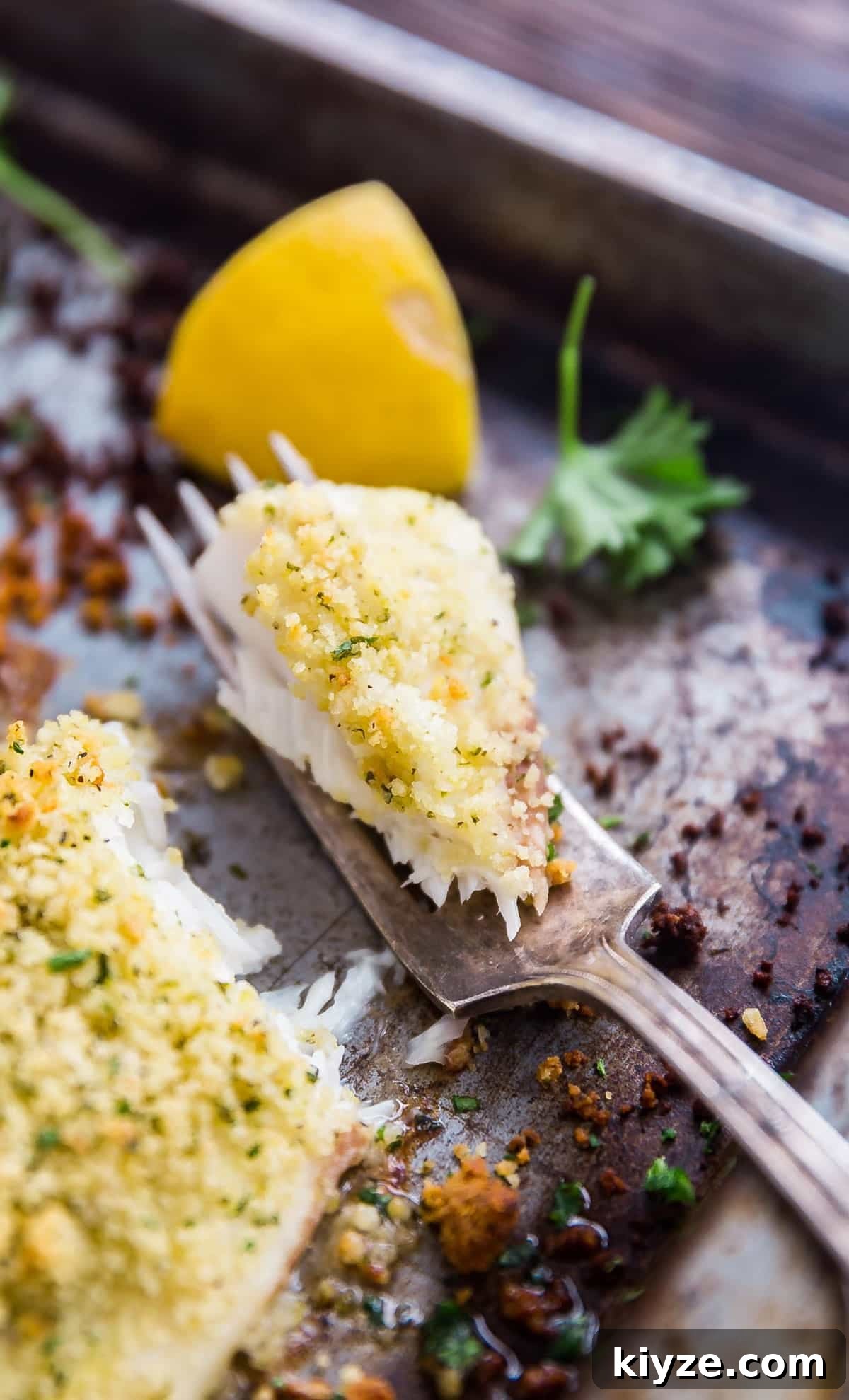 Crispy Parmesan-Crusted Fish Fillets Recipe 9 A close up image of a bite of fish on a fork.