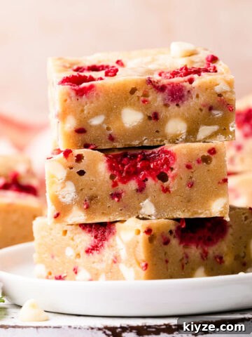 stack of three raspberry blondies stuffed with white chocolate chips