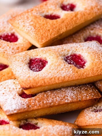 raspberry financiers cakes dusted with sugar and stacked on top of each other.