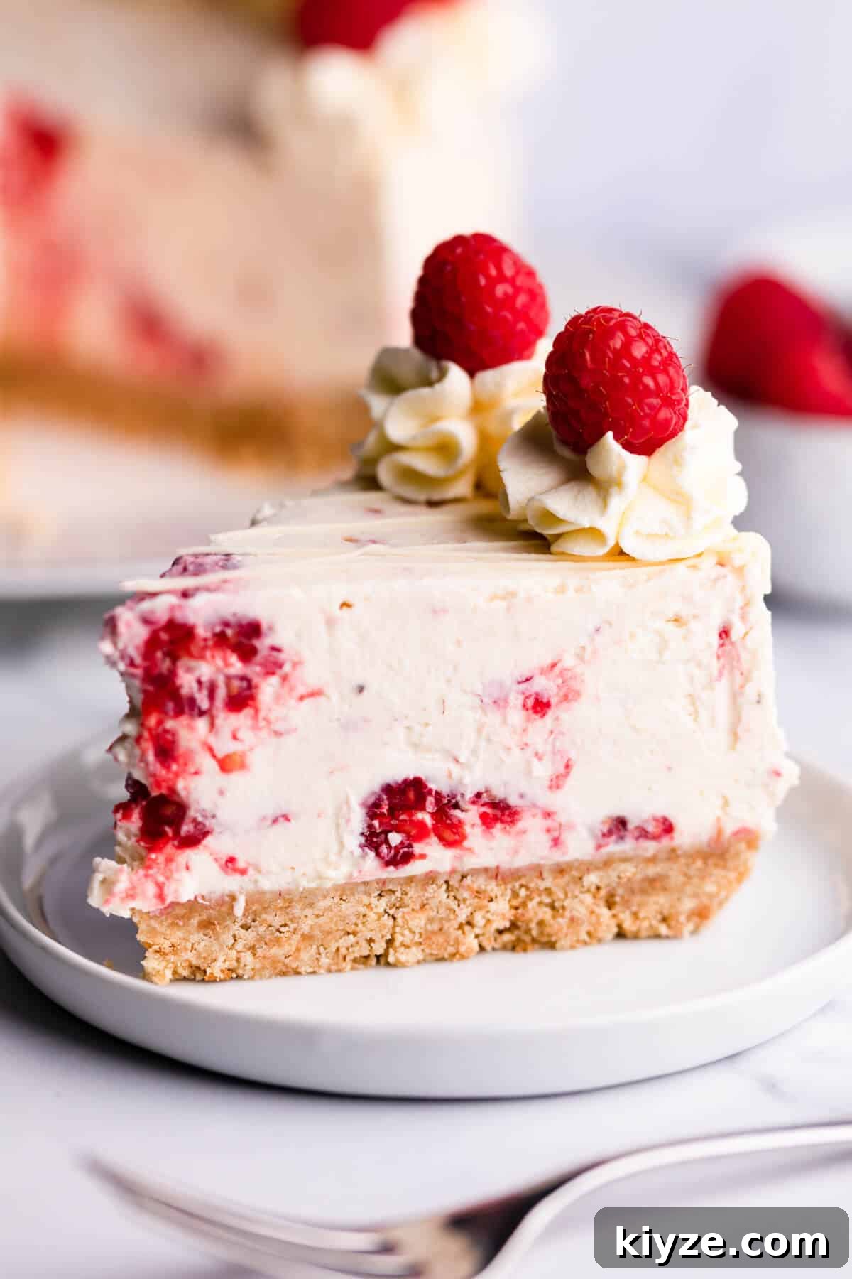 No-Bake Raspberry and White Chocolate Cheesecake Recipe 9 Slice of no bake cheesecake with fresh raspberries and white chocolate.