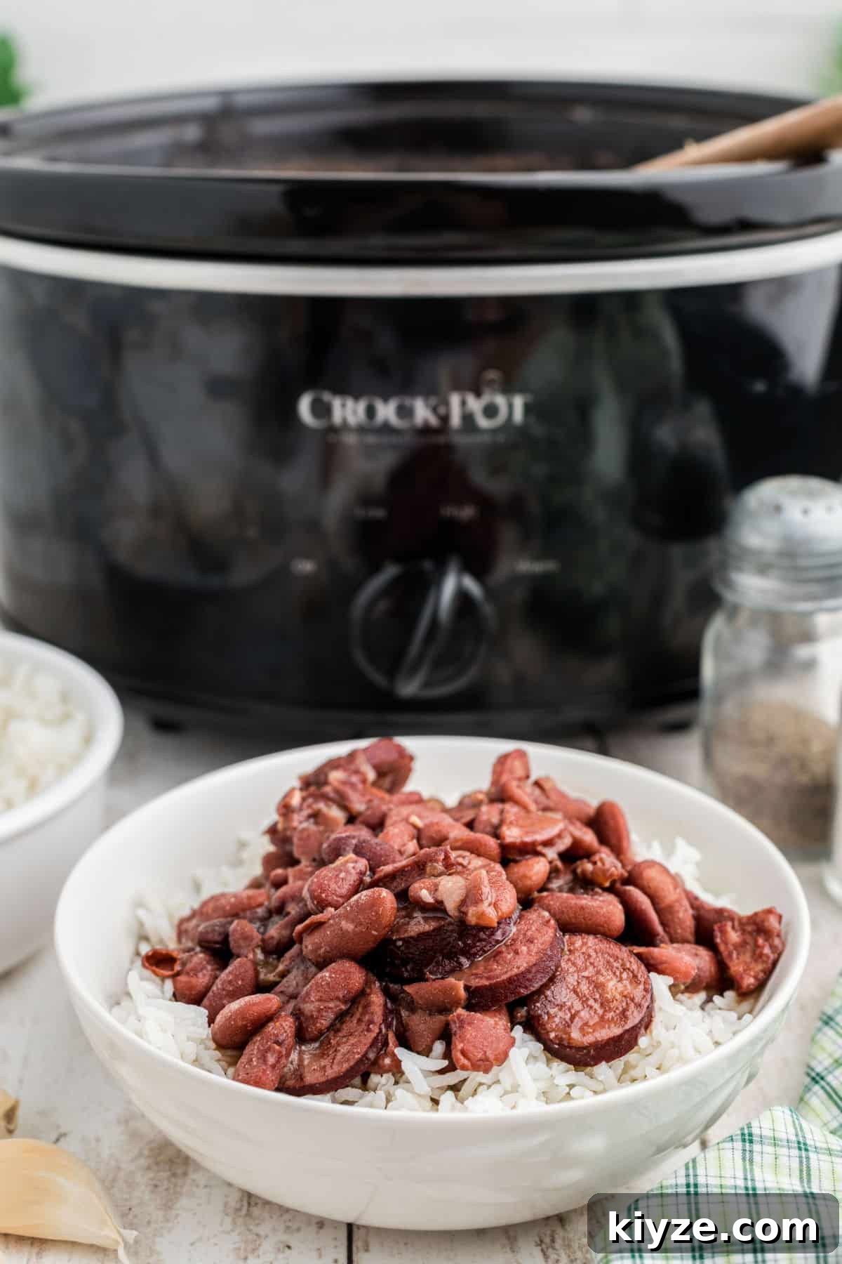 A bowl of Cajun Red Beans and Rice in front of a slow cooker.