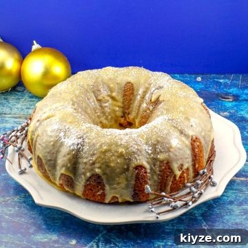 whole butter tart cake on a white plate with gold Christmas ornaments in background
