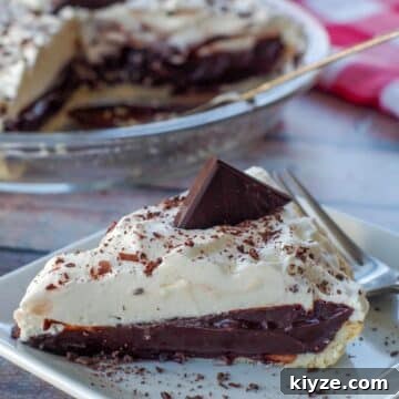 a piece of old fashioned chocolate pie on a white plate with a fork and more pie in the background