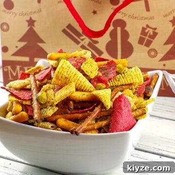 Christmas Chex Mix in a white bowl with a festive Christmas bag in the background