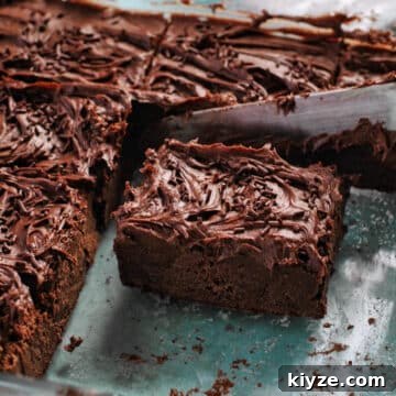 chocolate square being cut, in a glass baking dish