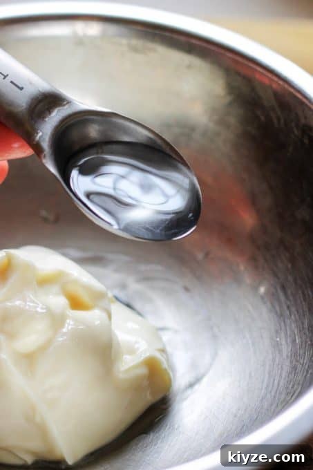 Adding water to mayonnaise to prepare sauce for Eggs Mayonnaise