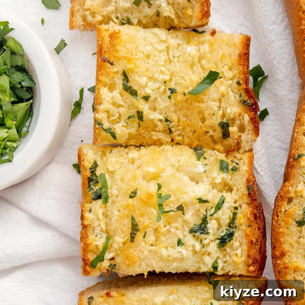 Crispy Garlic Crostini with Olive Oil and Herbs 11 Slices of garlic bread on a white cloth, garnished with chopped parsley.