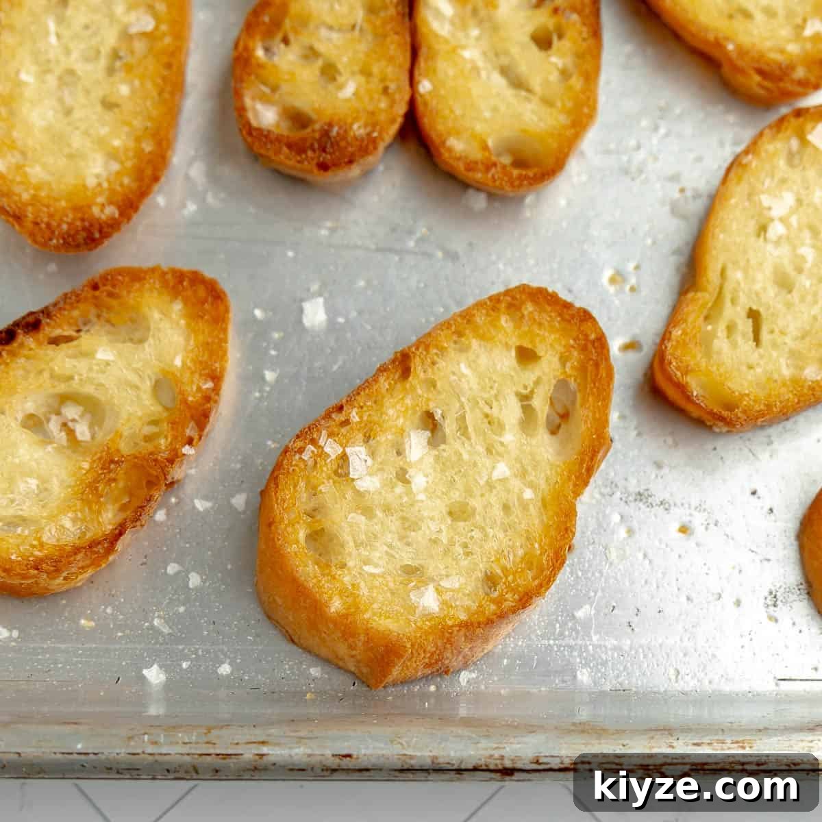 Crispy Garlic Crostini with Olive Oil and Herbs 9 Up close photo of toasted bread sprinkled with salt.