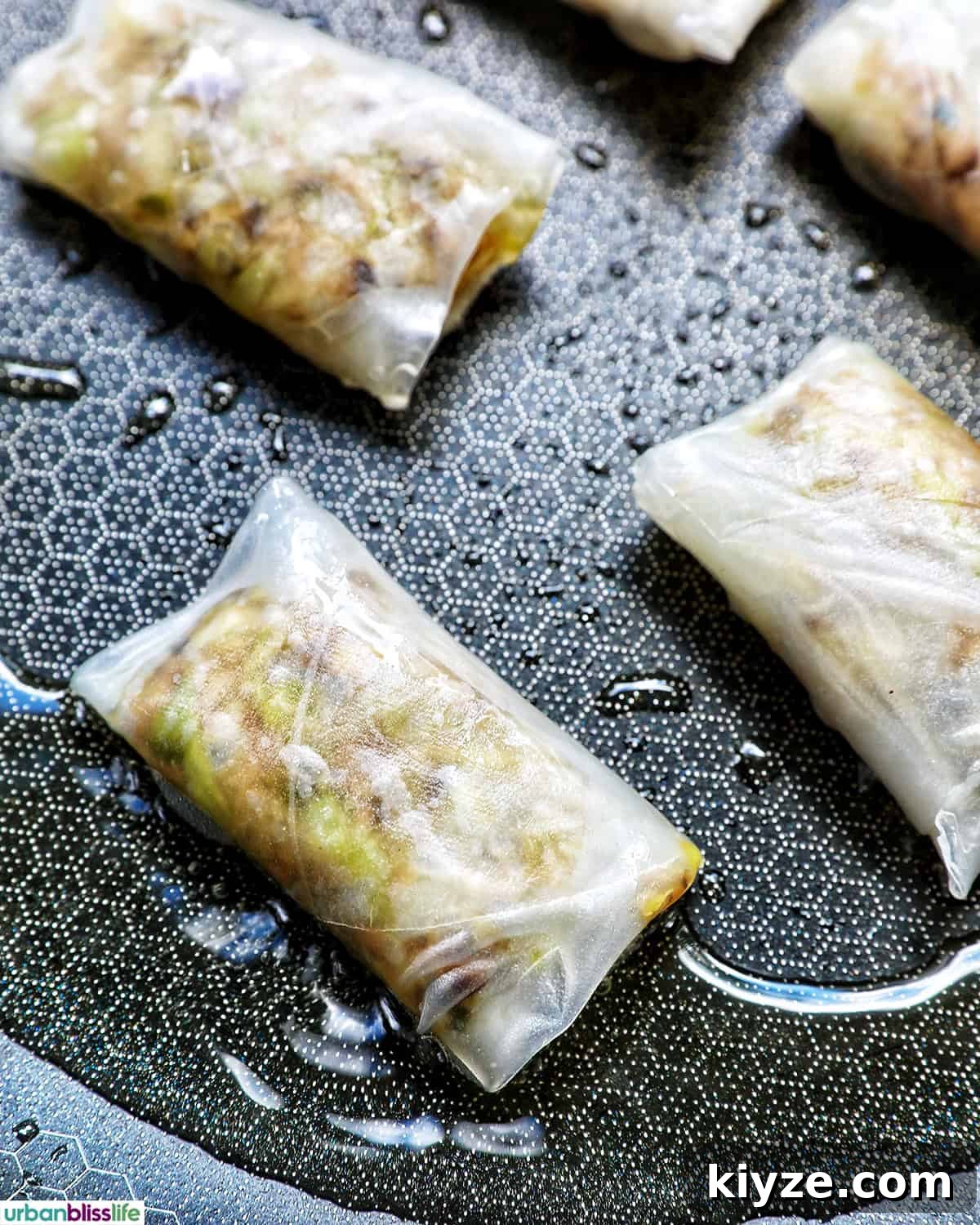 Crispy Rice Paper Dumplings with Savory Filling and Dipping Sauce 15 Filled and folded rice paper dumplings in a pan.