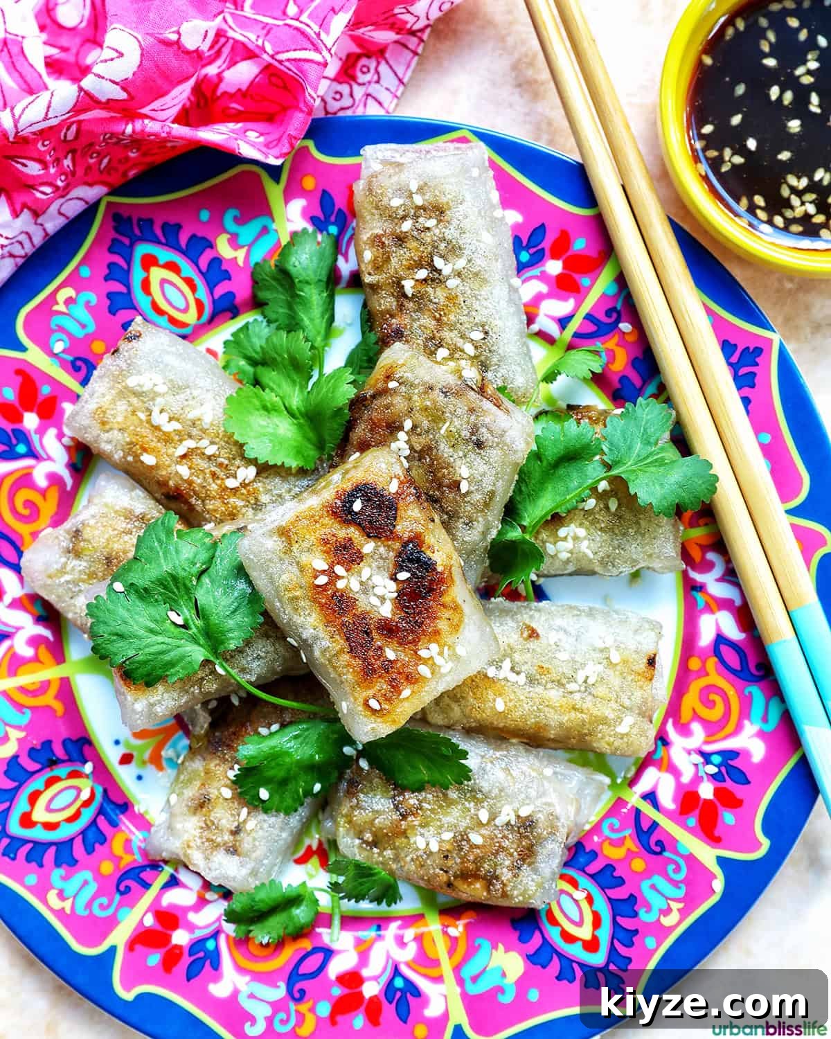 Crispy Rice Paper Dumplings with Savory Filling and Dipping Sauce 18 crispy rice paper dumplings on a plate with herbs.
