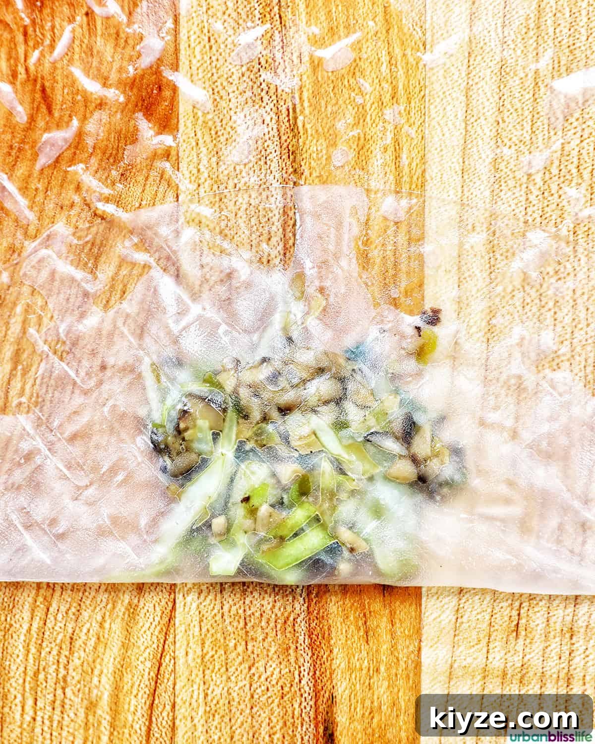 Crispy Rice Paper Dumplings with Savory Filling and Dipping Sauce 10 vegetable filling on top of a rice paper wrapper being folded.