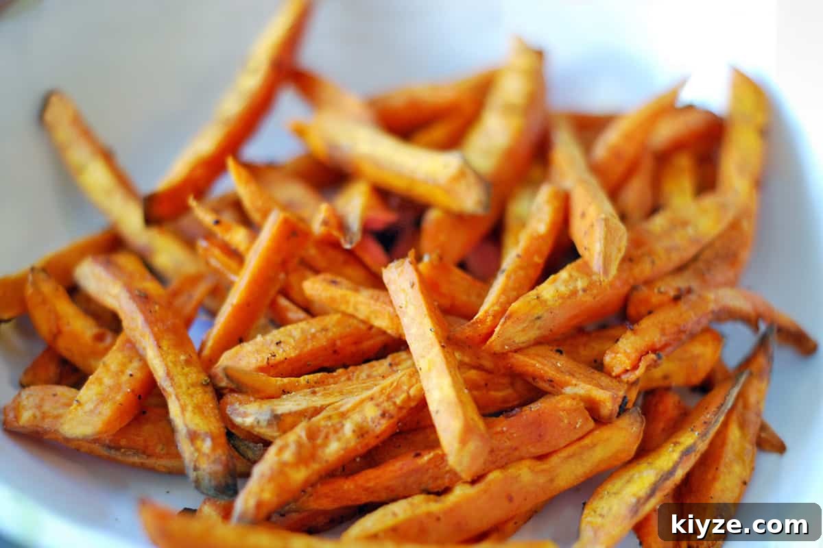 Crispy Sweet Potato Fries: Oven or Air Fryer Method 7 A closeup of a white bowl filled with sweet potato fries.