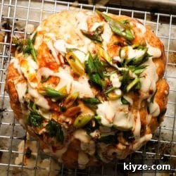 Miso Tahini Roasted Whole Cauliflower Recipe 6 Whole roasted cauliflower with miso tahini sauce and green onion garnish.
