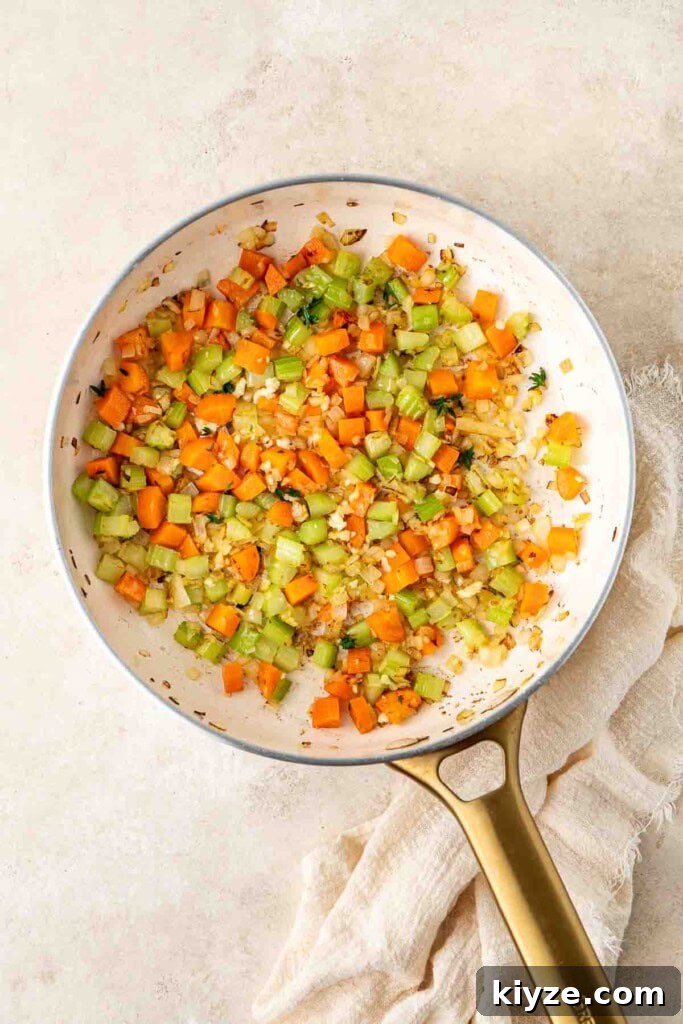 Dairy-Free Chicken Pot Pie Recipe: Creamy, Comforting Pie 5 Sautéing the vegetables for chicken pot pie in a frying pan.