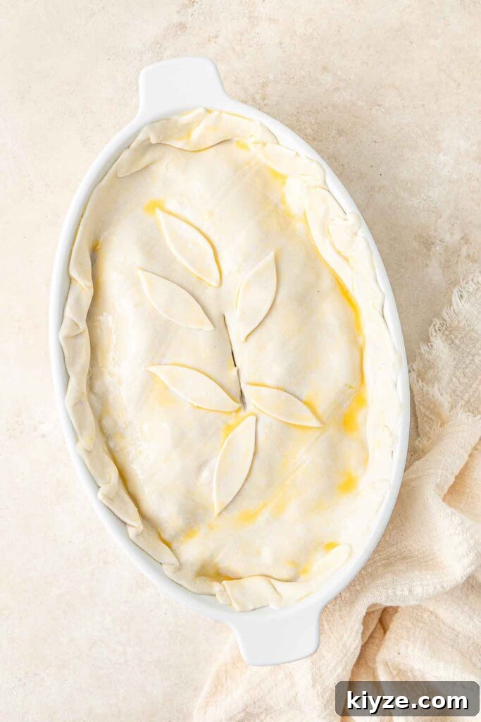 Dairy-Free Chicken Pot Pie Recipe: Creamy, Comforting Pie 8 The pastry covering the pie in a pie dish, ready for the oven.