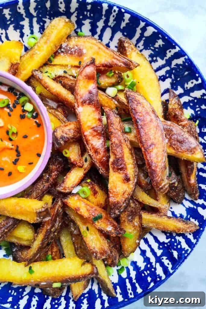 Crispy Dukkah Potatoes with Aioli & Pink Tahini Drizzle 19 Homemade oven chips with spicy gochujang aioli in a white and blue striped bowl.