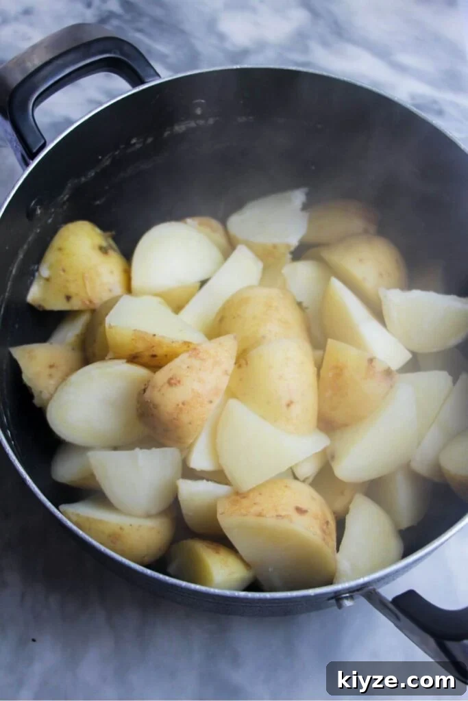 Crispy Dukkah Potatoes with Aioli & Pink Tahini Drizzle 4 Par-boiled potatoes in a large black pot.