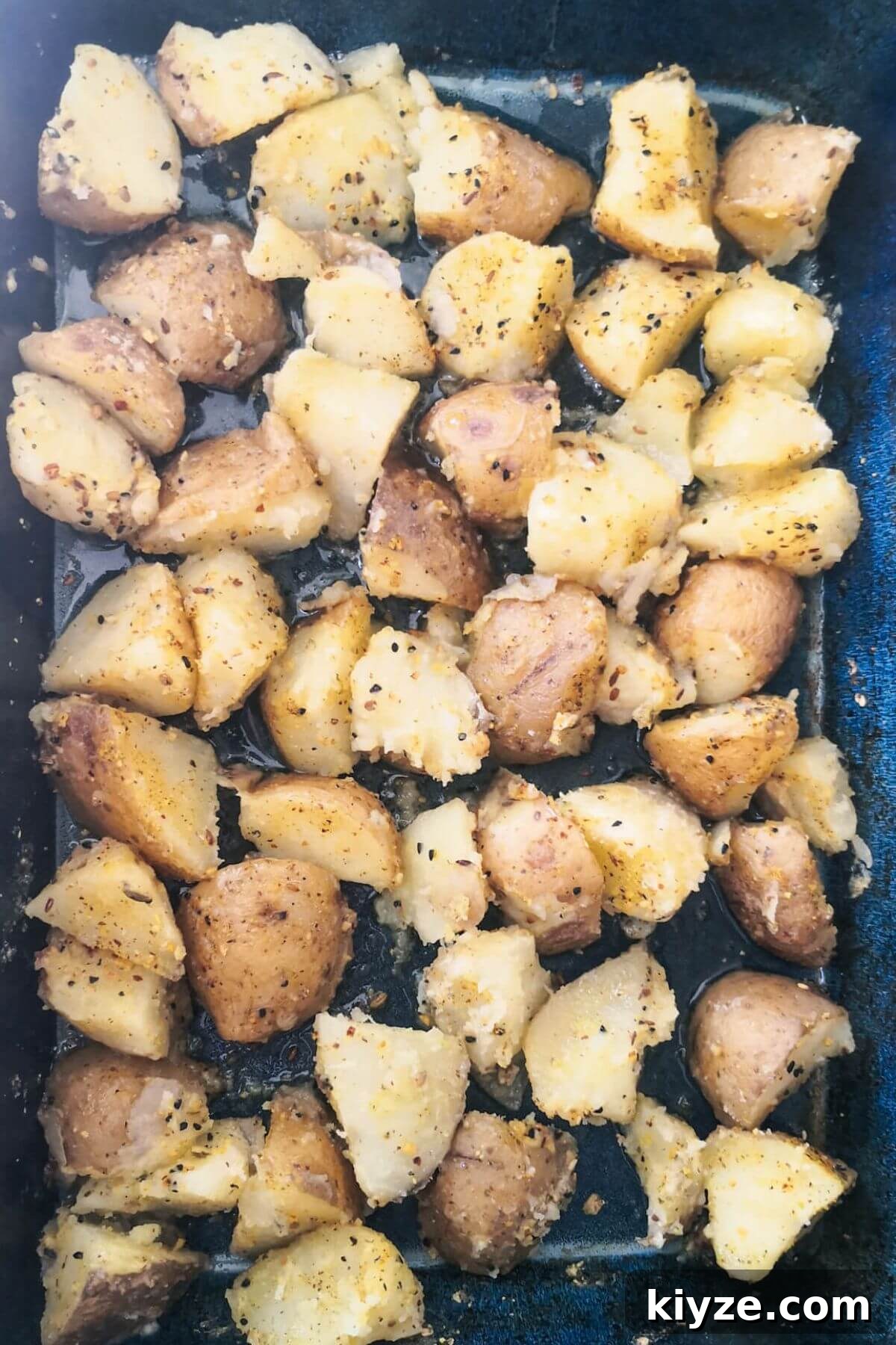 Crispy Dukkah Potatoes with Aioli & Pink Tahini Drizzle 6 Dukkah potatoes in a large blue oven dish ready to go into the oven.