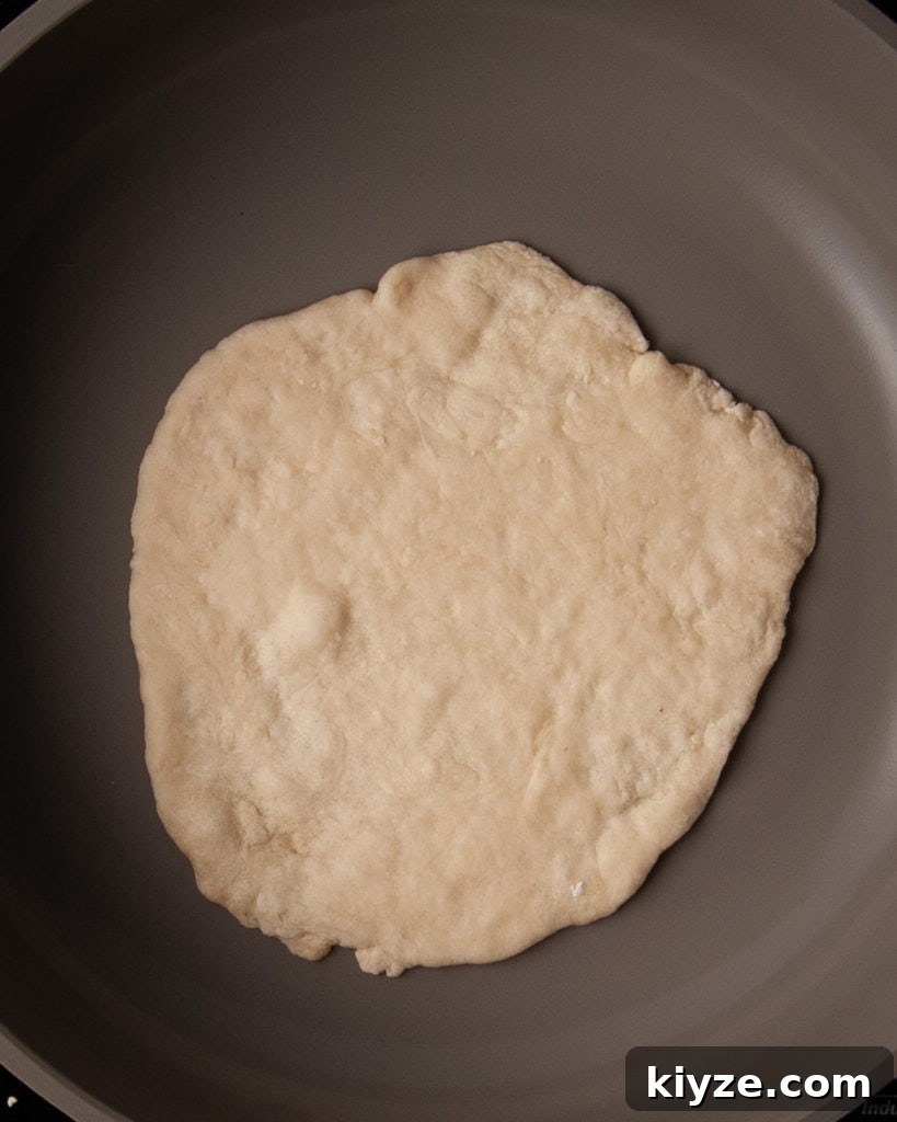 Adding homemade tortilla to hot frying pan.