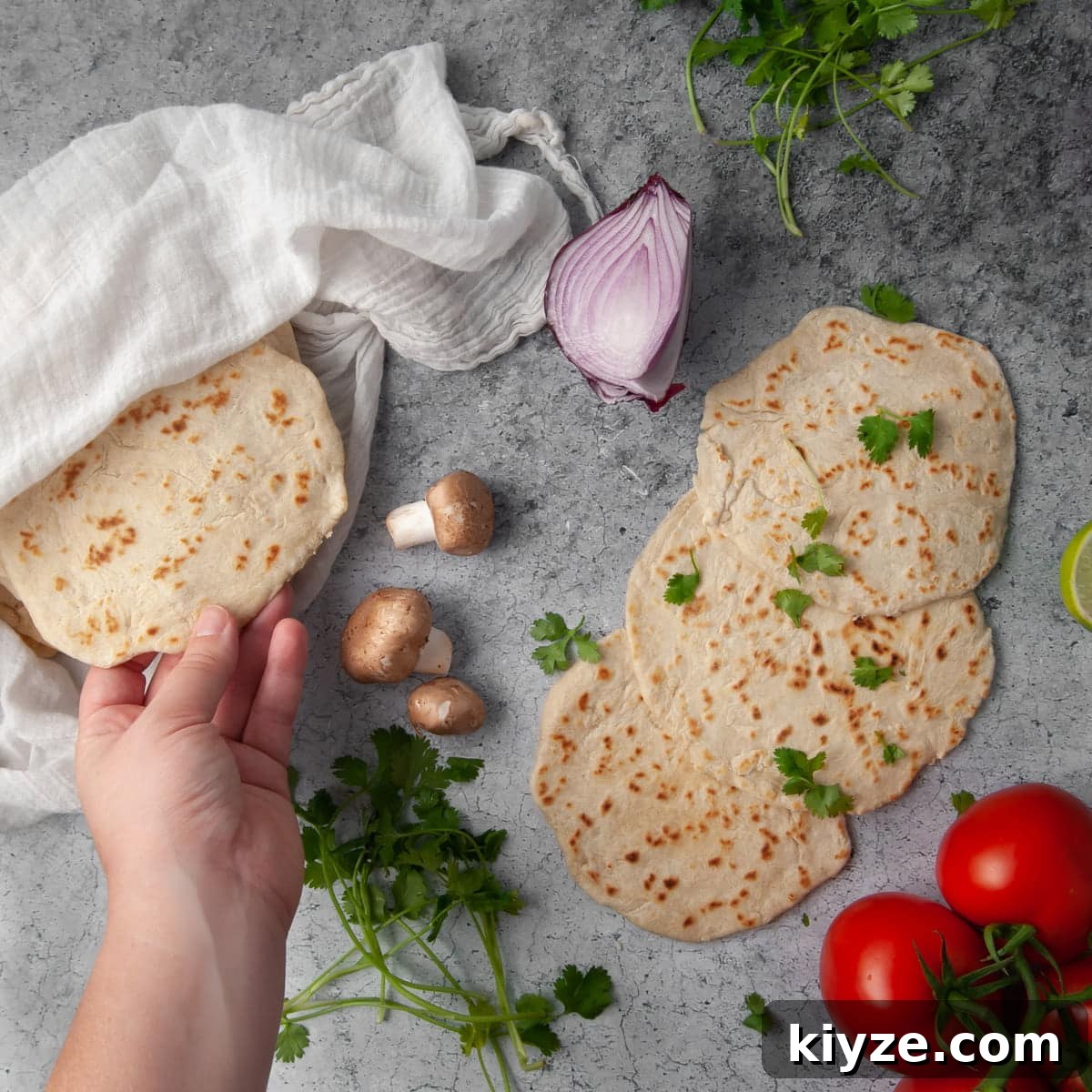 hand grabbing a tortilla from the pile to stuff it with fresh ingredients