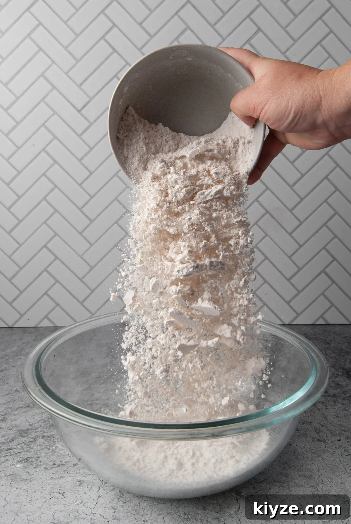 adding flour to a mixing bowl
