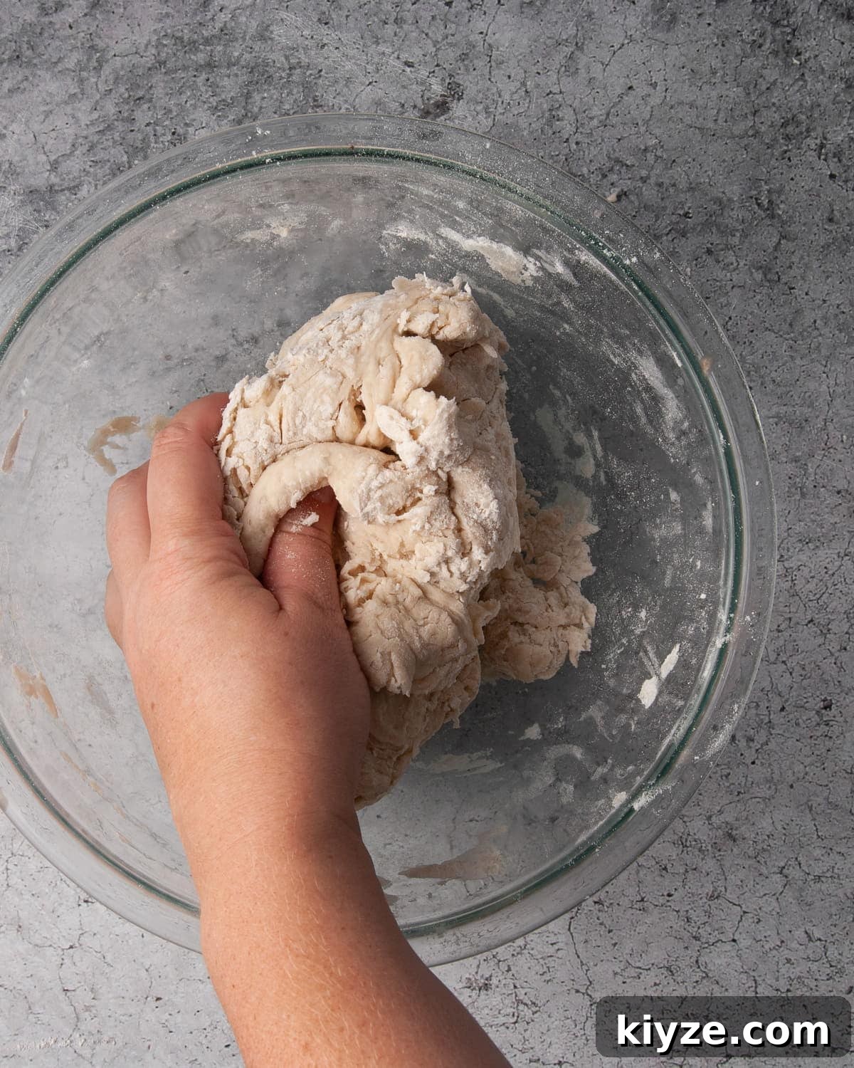 using hands to mix dough together
