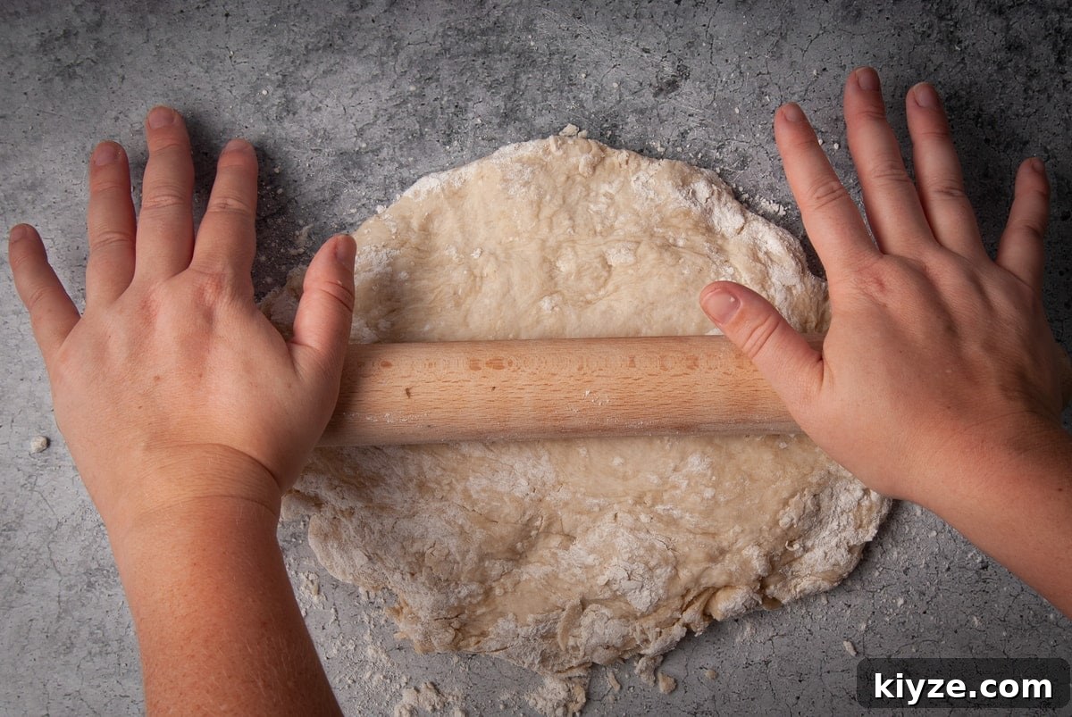 Using a rolling pin to flatten tortilla dough.