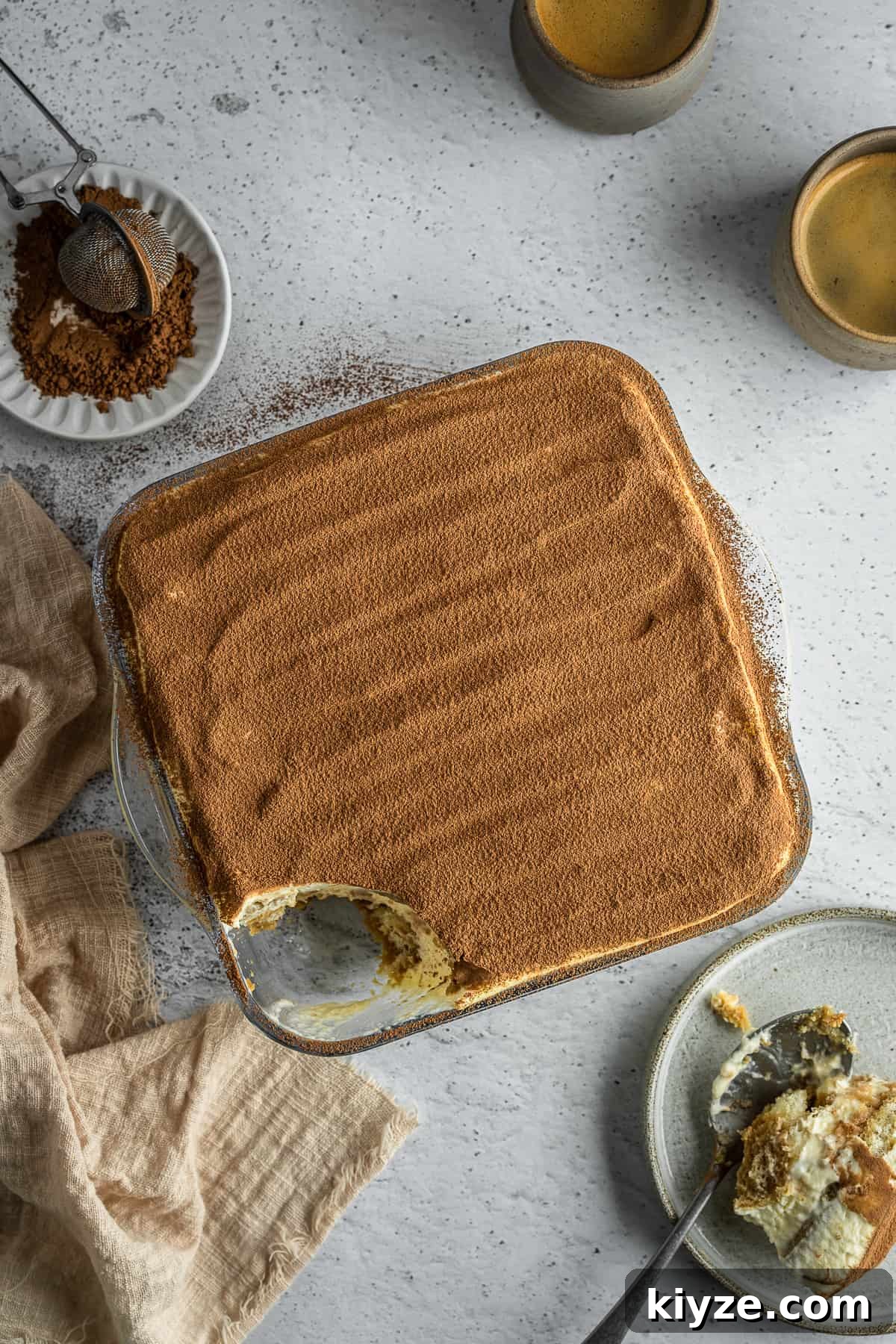 Classic Tiramisu with Marsala and Mascarpone Recipe 9 Marsala tiramisu sprinkled with cocoa powder in a glass dish.
