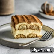 Slice of original tiramisu on a dessert plate with a fork.