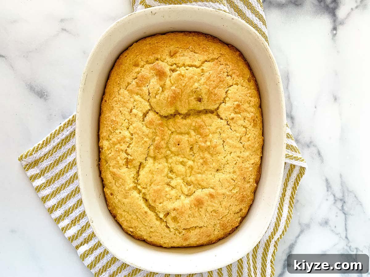 Jiffy Cornbread with Creamed Corn Casserole Recipe 11 horizontal photo of a casserole with Jiffy cornbread with creamed corn.