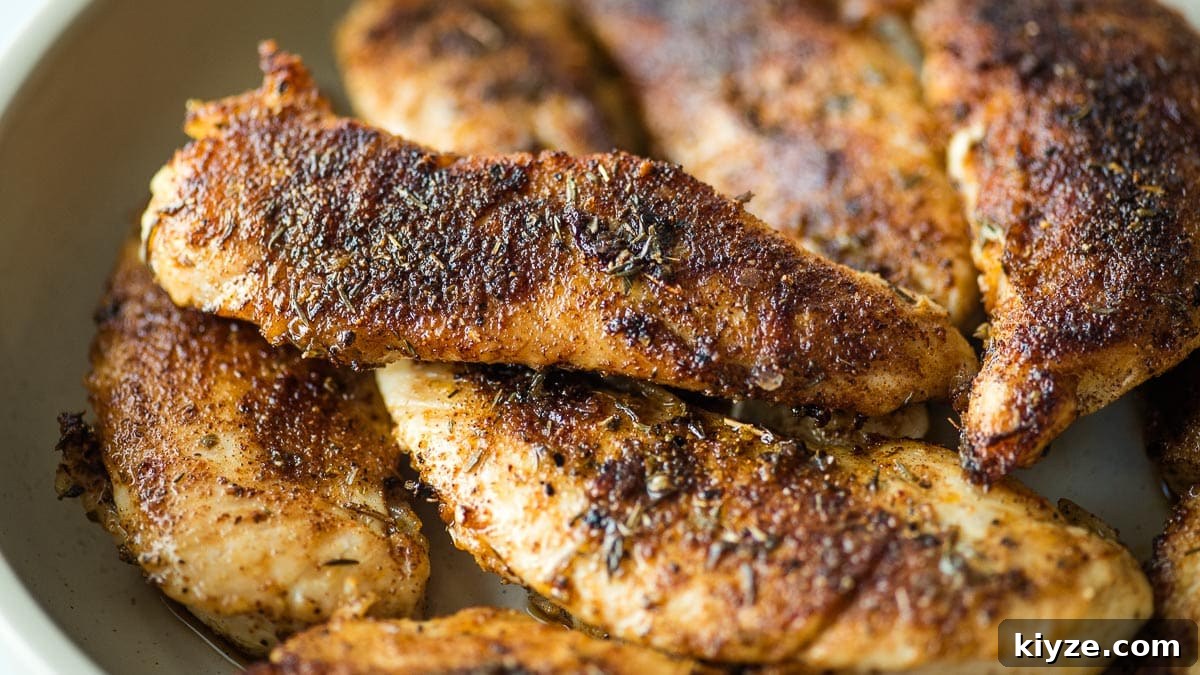 Cajun Blackened Chicken Tenders with Zesty Dipping Sauce 11 Blackened chicken tenders in a white bowl on a table.