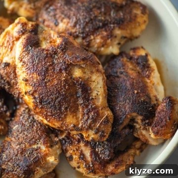 Blackened chicken thighs in a white bowl.