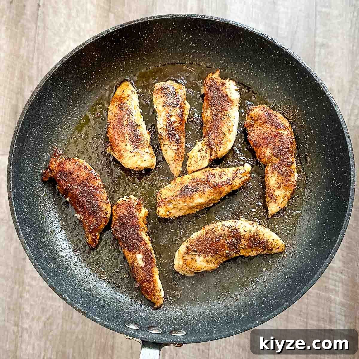 Cajun Blackened Chicken Tenders with Zesty Dipping Sauce 8 Cooked blackened chicken tenders in a frying pan.