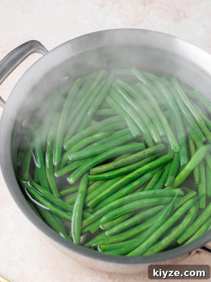 stainless steel pot with boiling water and green beans