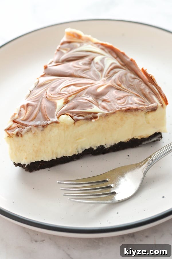 No-Bake Marble Cheesecake Recipe: Creamy Swirl No-Bake Cake 2 a slice of marble cheesecake with a fork on the plate.