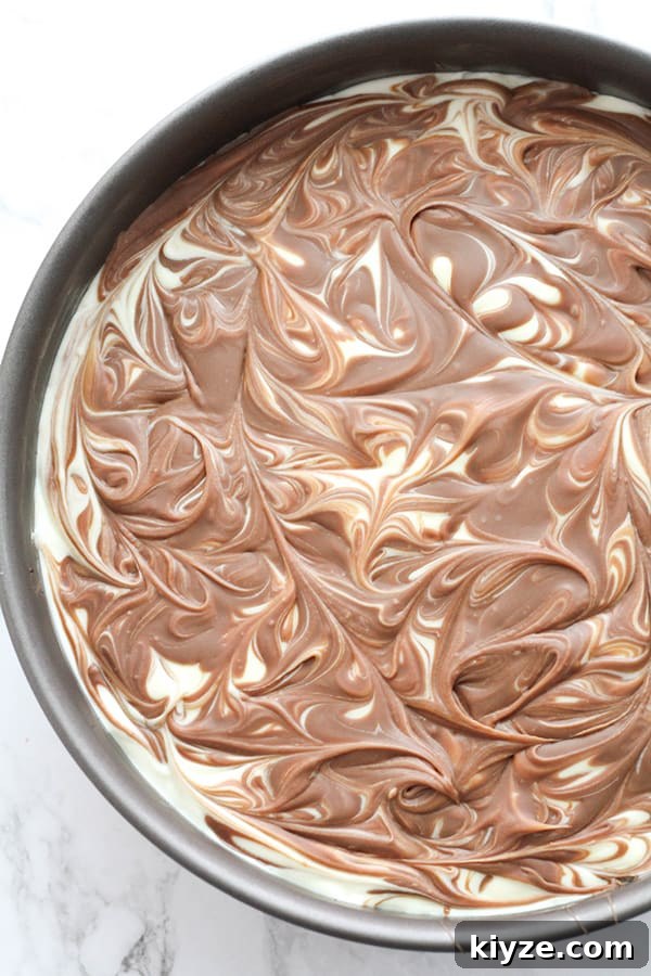No-Bake Marble Cheesecake Recipe: Creamy Swirl No-Bake Cake 10 chocolate swirl on top of cheesecake.