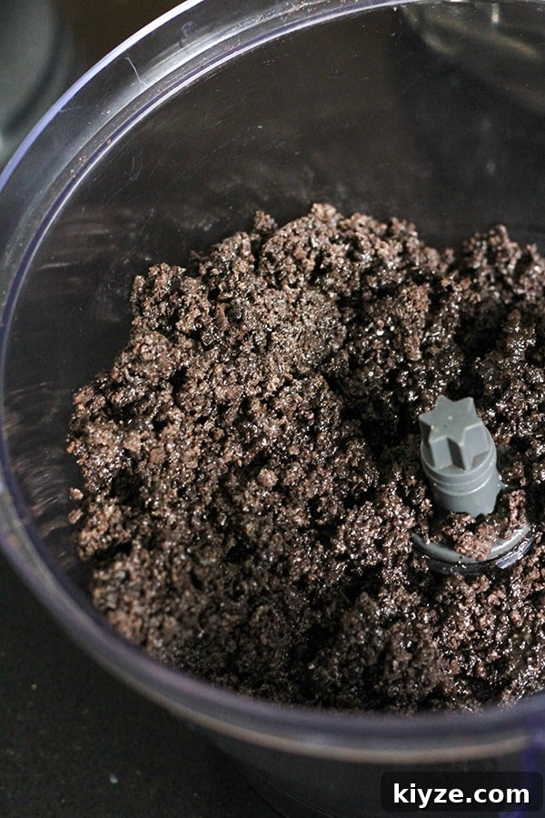 No-Bake Marble Cheesecake Recipe: Creamy Swirl No-Bake Cake 6 oreo crumbs mixed with butter in a bowl.