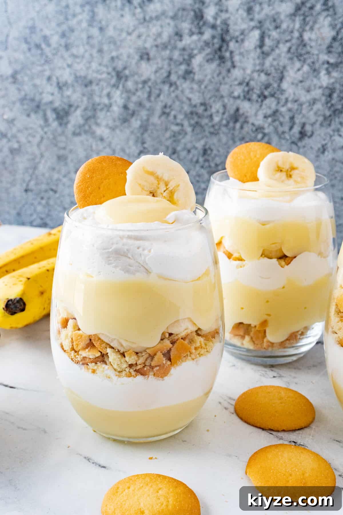 Layered pudding, sliced bananas, crushed cookies, and Cool Whip in cups. Garnished with a banana slice and a Nilla wafer.