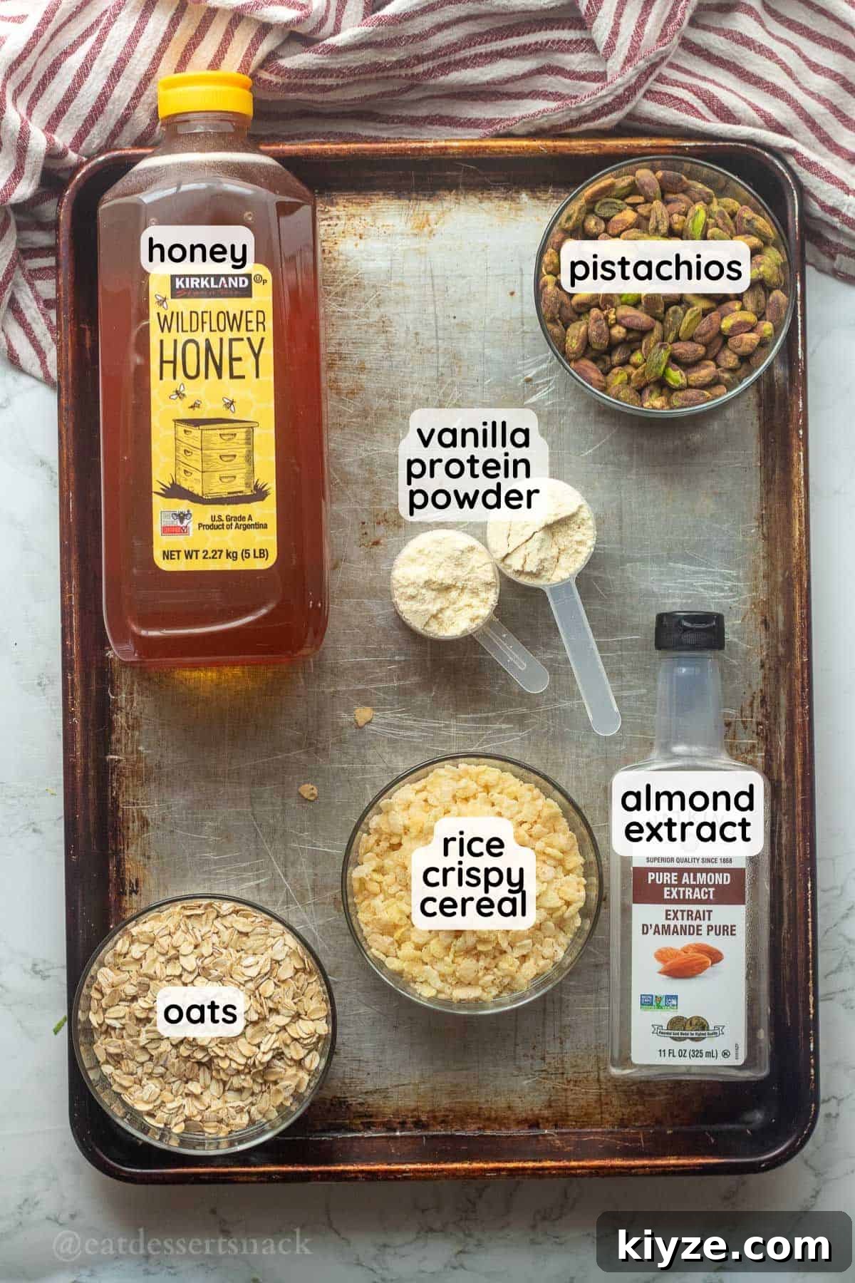 Ingredients labeled for pistachio protein bites on metal pan in bowls.