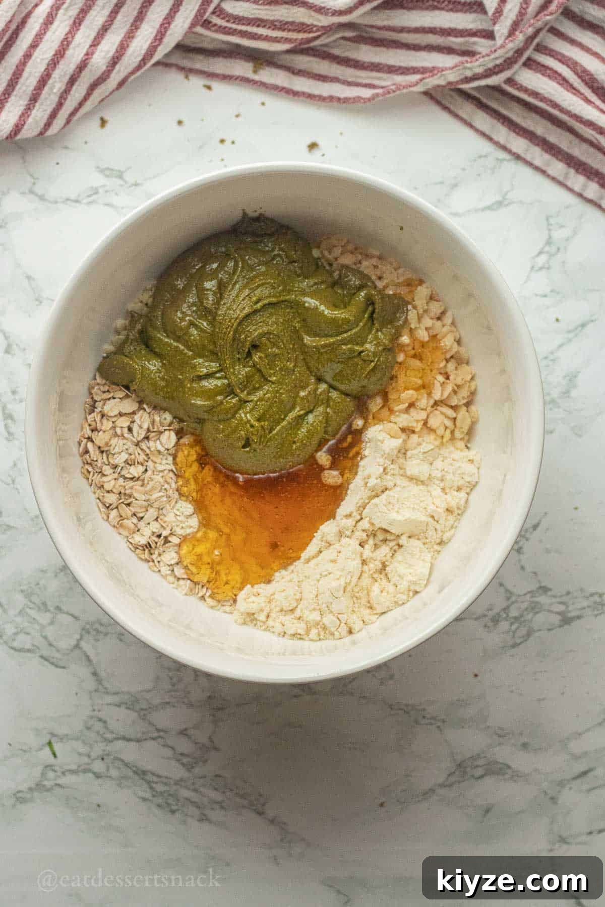 Pistachio butter, honey, and dry ingredients in a bowl.