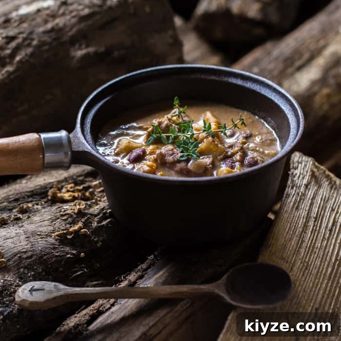 Caribbean Pepperpot Stew Made in the Slow Cooker 4 Slow Cooker Pepperpot Stew in a pan on a piece of wood with a serving spoon