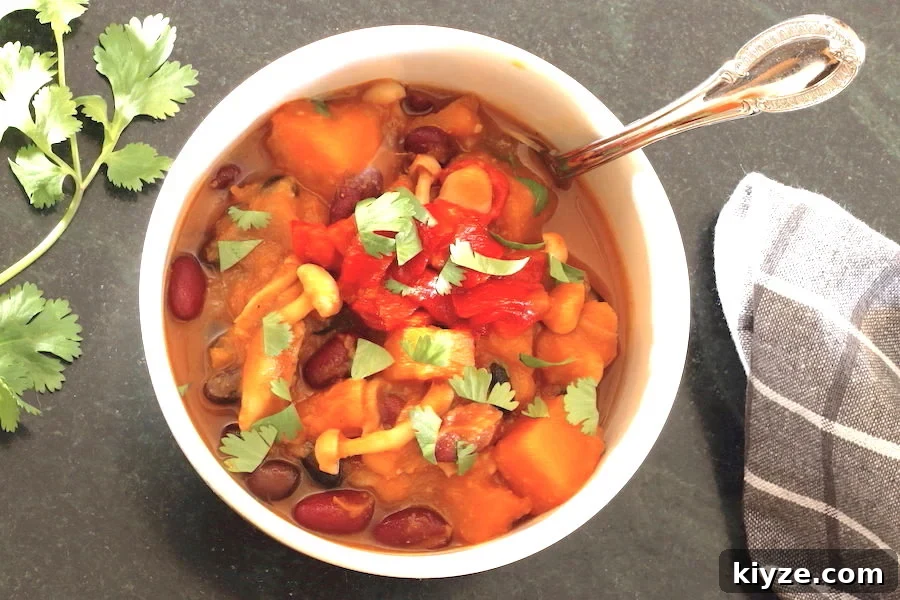 Butternut Squash Chili in a bowl with sprig of cilantro t the side