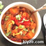Butternut Squash Chili in a bowl with sprig of cilantro t the side