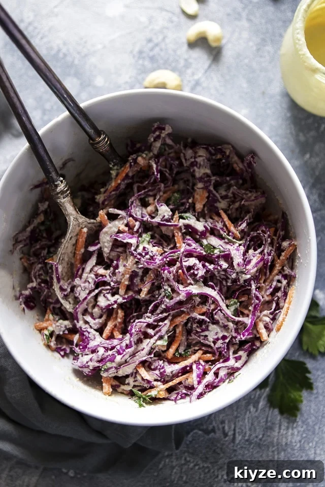 Purple Cabbage Slaw in a White Bowl with Utencils