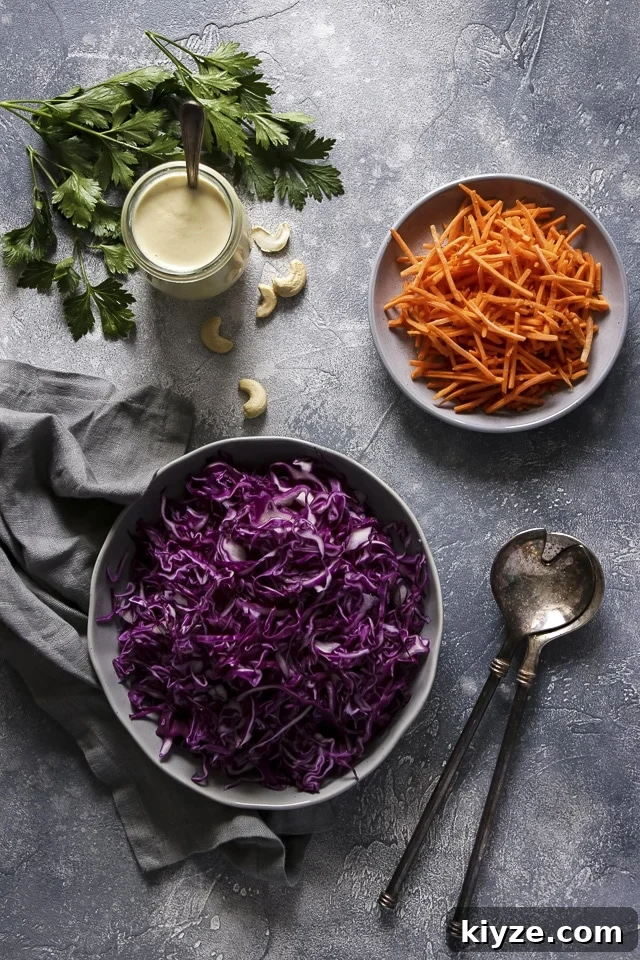 Shredded Purple Cabbage and Shredded Carrots Next to a Jar of Vegan Mayo and Parsley