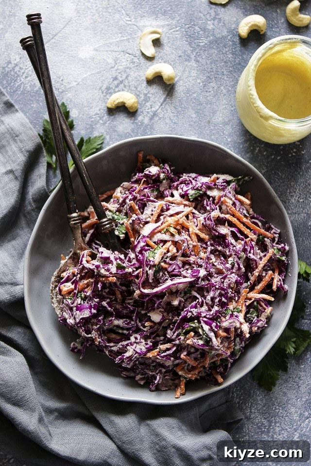 Vegan Coleslaw Salad on a Plate Next to a Jar of Vegan Cashew Mayo