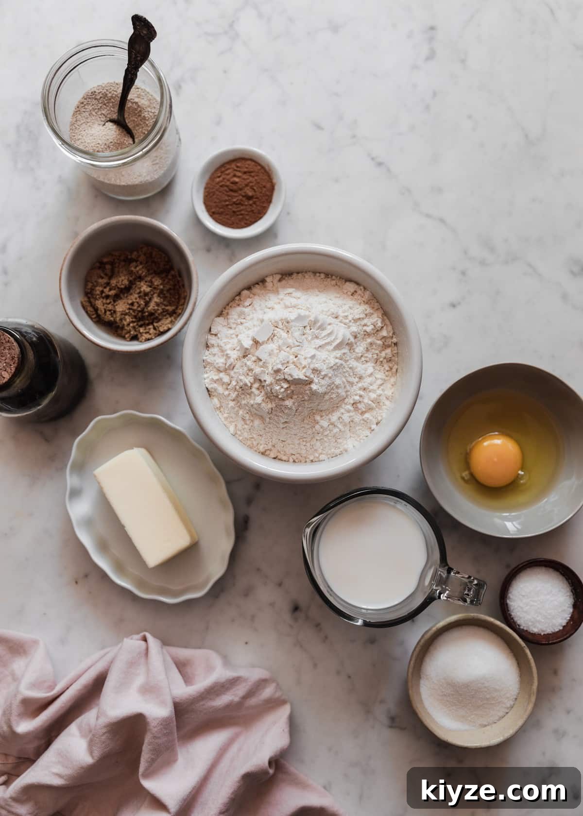Cinnamon Swirl Bread with Crumbly Streusel Topping 4 Various white and grey bowls of baking ingredients including flour, butter, brown sugar, and egg, salt, and vanilla on a marble counter next to a pink linen.