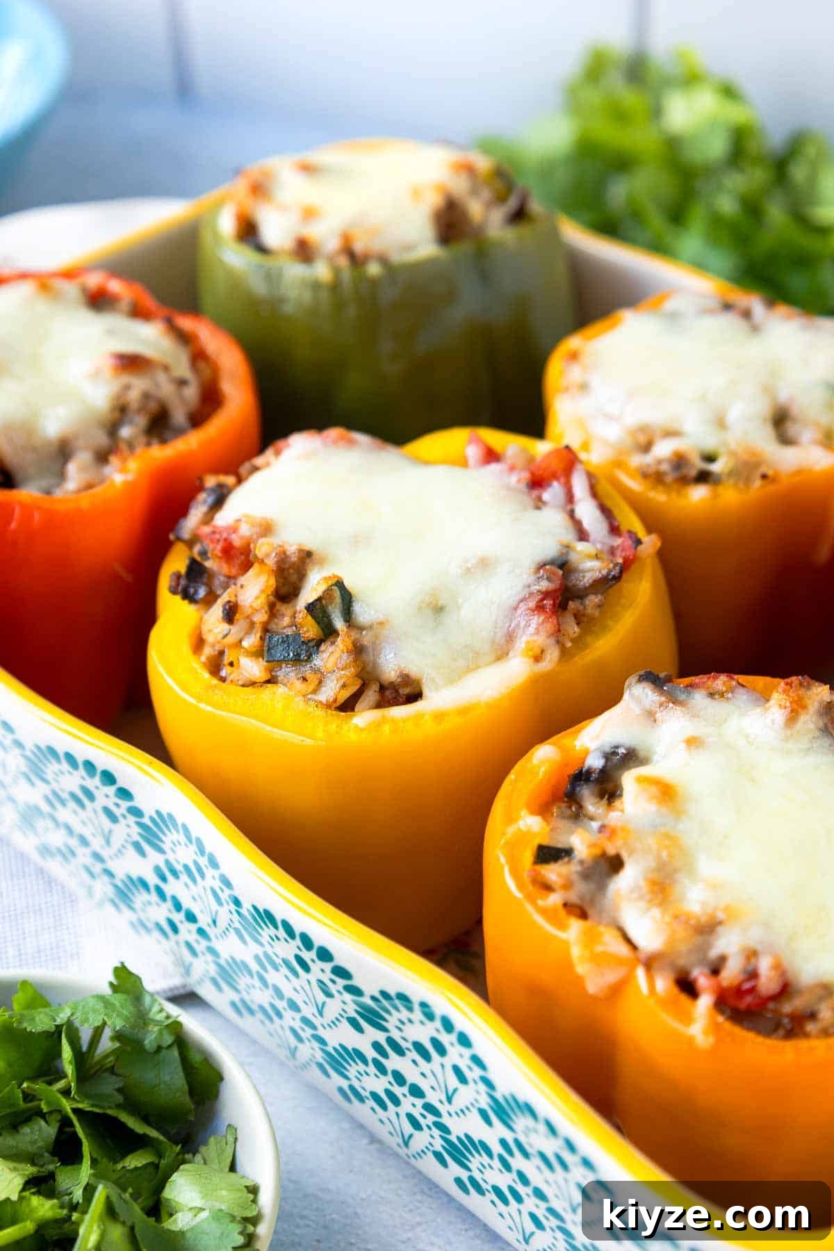Ground Turkey and Rice Stuffed Bell Peppers Recipe 2 Baking dish with six multicolored stuffed bell peppers topped with melted mozzarella cheese