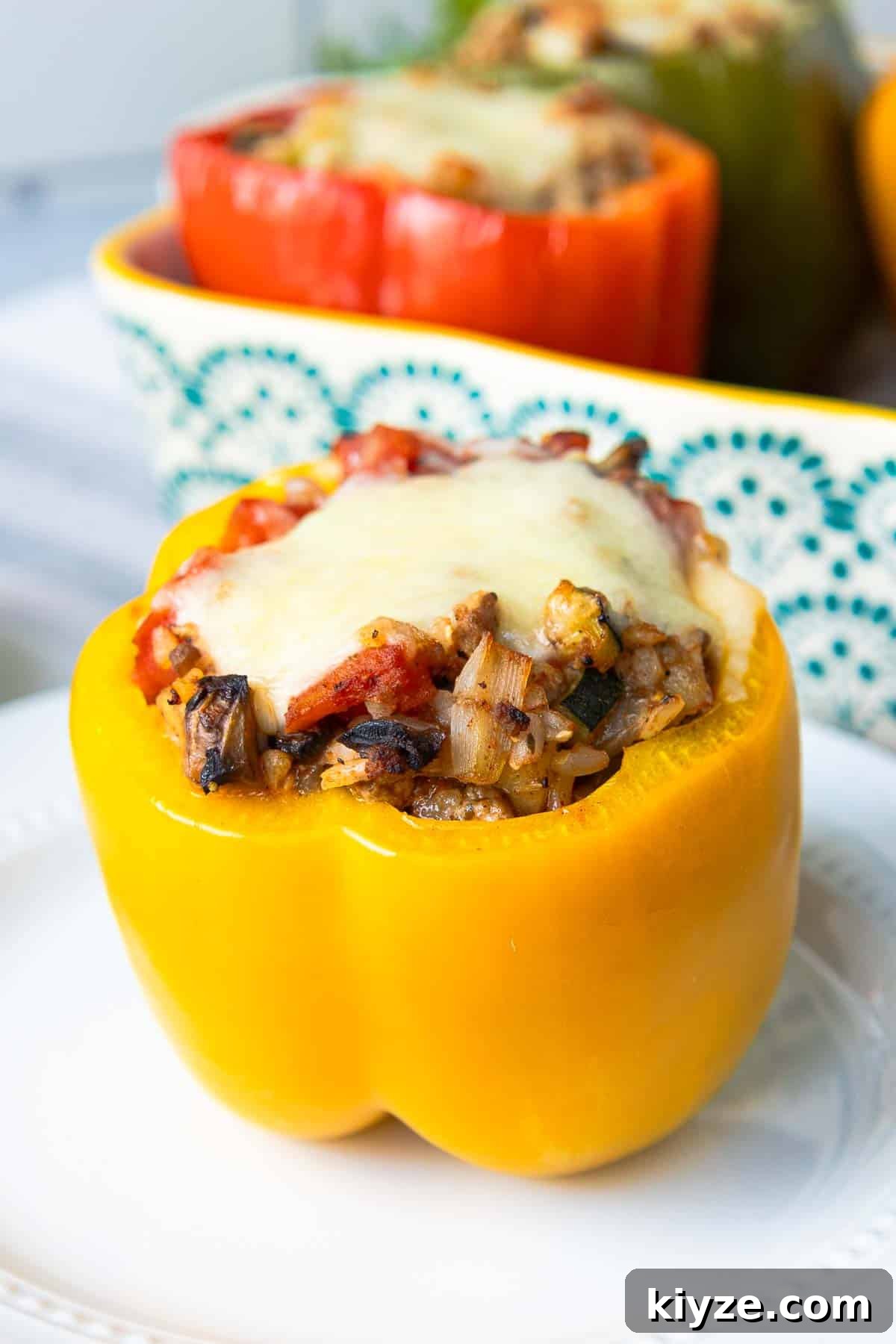 Ground Turkey and Rice Stuffed Bell Peppers Recipe 13 Ground turkey stuffed yellow bell peppers standing upright topped with melted mozzarella cheese